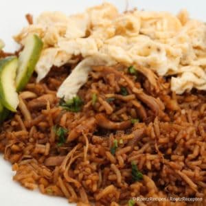 Surinamese Nasi with cucumber and egg on a white plate